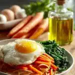 Plate of crispy Korean Fried Noodles garnished with vegetables and herbs